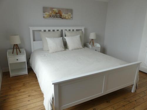 una camera con un letto bianco con due comodini di GÎTE L'ISABEY ETRETAT a Étretat