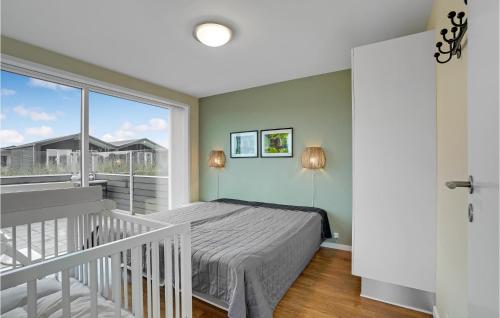 スナーヴィグにあるBeautiful Home In Ringkbing With House A Panoramic Viewのベッドルーム(ベッド1台付)、バルコニーが備わります。
