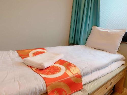 uma cama com duas almofadas em cima em Jing House akihabara Ryokan - Vacation STAY 30899v em Tóquio