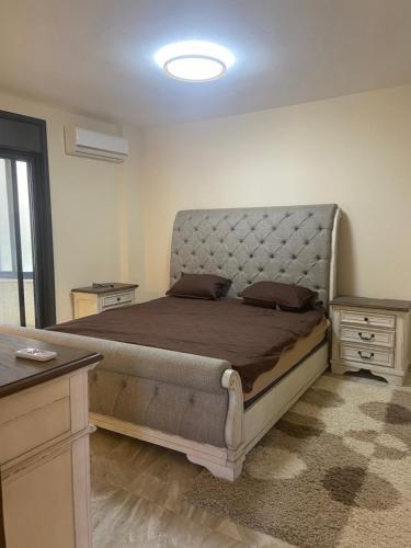 a bedroom with a large bed with a large headboard at Atlantis-Alterah in Ramallah