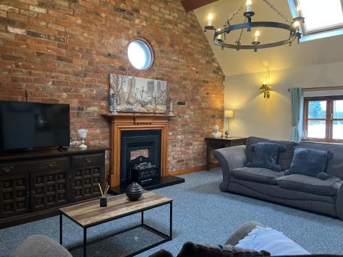 a living room with a couch and a fireplace at Pillory House Loft Apartment in Nantwich
