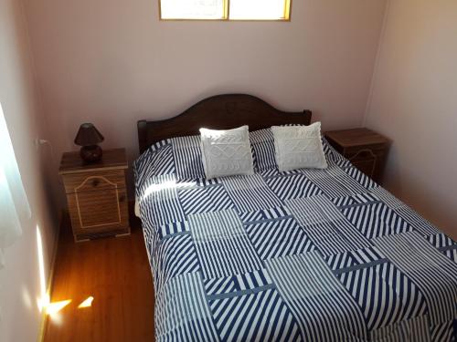 Schlafzimmer mit einem Bett mit einer blauen und weißen Bettdecke in der Unterkunft Rosa Herminia in Limache