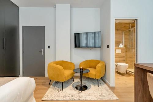 アヌシーにあるLoge Galeries Lafayette 1 min lacのベッドルーム(黄色の椅子2脚、テーブル付)