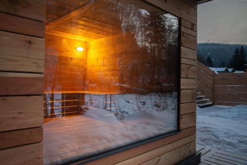 a jacuzzi in a wooden building with a light on it at VagusBouda/ &Fogo in Loučná nad Desnou