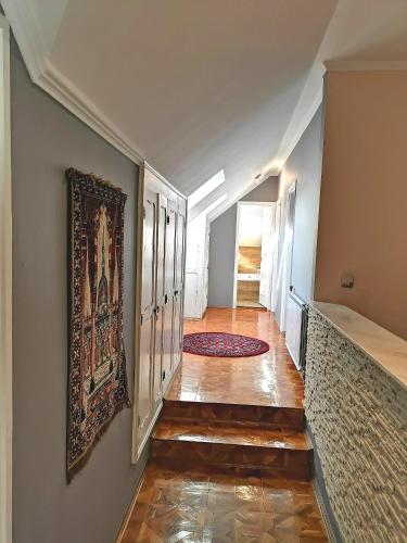 a hallway with a painting on the wall and a rug at Villa Wellness in Budapest