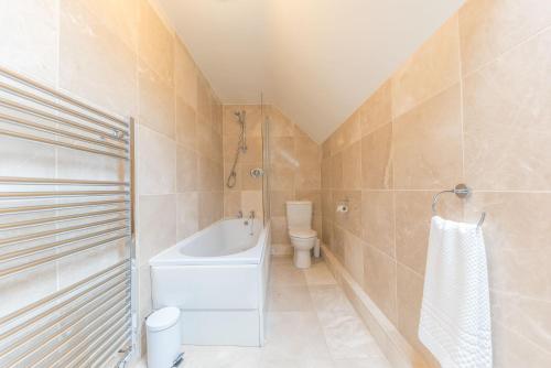 ein Badezimmer mit einer Badewanne, einem WC und einem Waschbecken in der Unterkunft Tower Cottage Far Sawrey Windermere in Far Sawrey