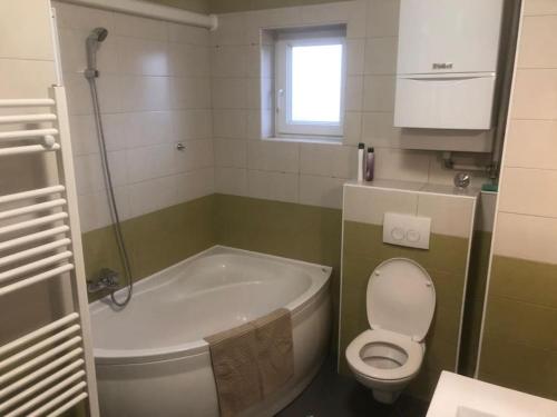 y baño con bañera, aseo y lavamanos. en Apartman Arena-Velesajam VITO, en Zagreb