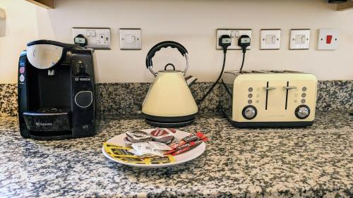 a kitchen counter with a tea kettle and a toaster at Leamington Spa Warwick Place Apartments in Leamington Spa