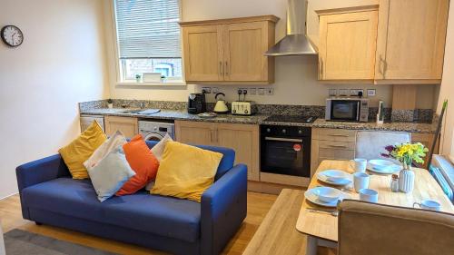 a living room with a blue couch and a table at Leamington Spa Warwick Place Apartments in Leamington Spa