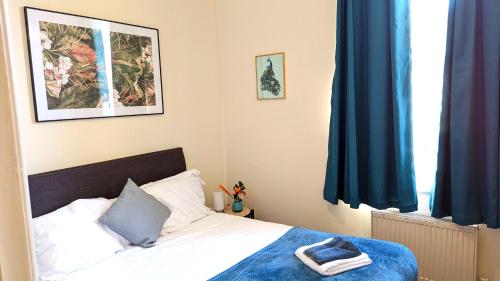 a bedroom with a bed and a window with blue curtains at Leamington Spa Warwick Place Apartments in Leamington Spa