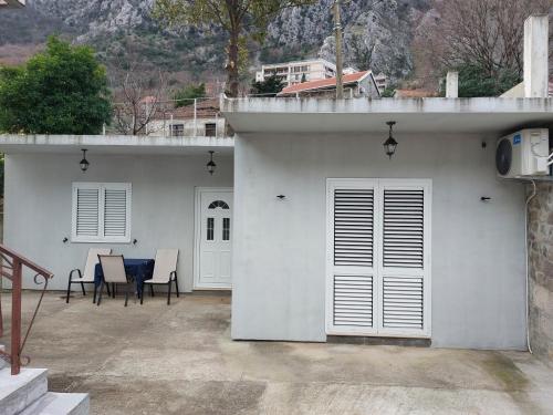 Casa blanca con patio con mesa y sillas en Apartment Angel, en Kotor