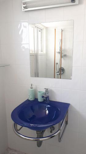 a bathroom with a blue sink and a mirror at סטודיו חדש ויפה עם נוף לים in Netanya