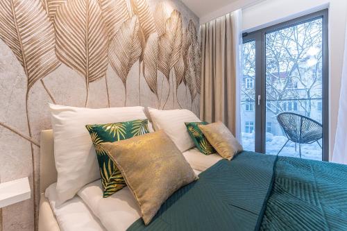 a bedroom with a bed with pillows and a wall with feathers at Pomorskie Apartamenty Monte Cassino 27 Deluxe in Sopot