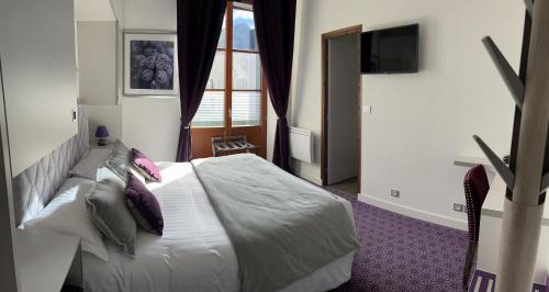 Ένα ή περισσότερα κρεβάτια σε δωμάτιο στο Logis Hôtel des Messageries