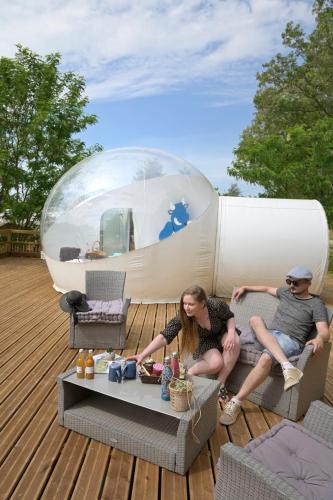 een man en een vrouw op een dek met een capsule bij Bulle SPA Romantique in Jarcieu