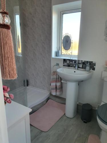 a bathroom with a sink and a tub and a toilet at HOME from HOME GUEST HOUSE in Rochford