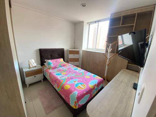 a small bedroom with a bed and a television at Apto a 5 minutos del parque principal in Sabaneta