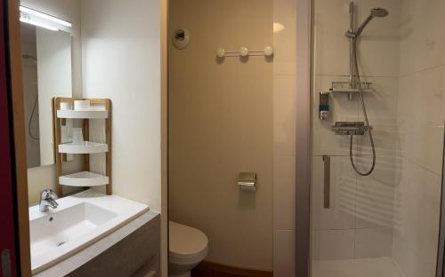 La salle de bains est pourvue d'une douche, de toilettes et d'un lavabo. dans l'établissement Logis Hôtel des Messageries, à Arbois