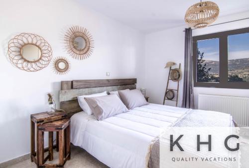 una camera da letto con un grande letto bianco e specchi di Majestic view Boho style retreat! ad Argostoli