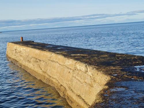 a concrete wall in the water next to the ocean at Victoria Hotel in Portknockie