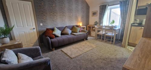 a living room with a couch and a table at Mains Street Retreat in Lockerbie