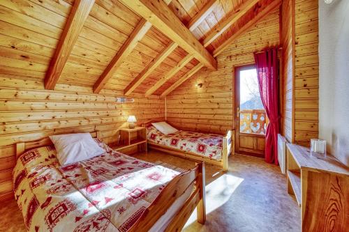 sypialnia z 2 łóżkami w drewnianym domku w obiekcie Chalet l'Hermine w mieście La Toussuire