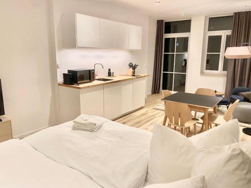 a living room with a bed and a kitchen at City Lofts Tegernsee - Moderne Studios zentral gelegen in Bad Wiessee