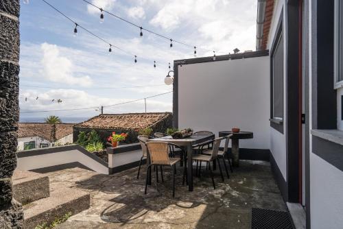 a patio with a table and chairs and a whiteboard at Quinta Pereirinha Farm - A Private 3 Bedroom Vacation Home, Close to Hiking w Ocean Views - Pico Island, Azores in São Roque do Pico