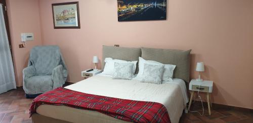 a bedroom with a bed and a chair at Suite Felix in Fiumicino
