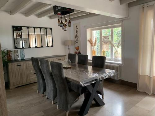 comedor con mesa y sillas en Cottage chaleureux au cœur des Monts de Flandres, en Saint-Jans-Cappel