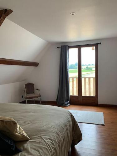 une chambre avec un lit et une porte coulissante en verre dans l'établissement Cottage chaleureux au cœur des Monts de Flandres, à Saint-Jans-Cappel