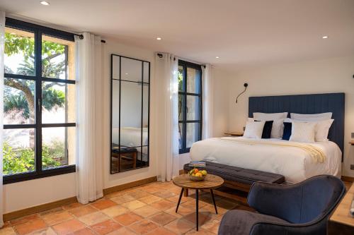 a bedroom with a bed and a table and chairs at Le Clos de Mansart in Grimaud