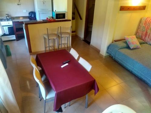 una mesa y sillas en una sala de estar con cocina en Cabañas Teo en El Bolsón