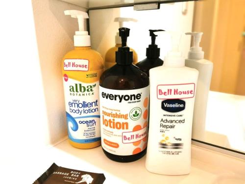 four bottles of cleaning products sitting on a bathroom counter at Bell house in Tokyo