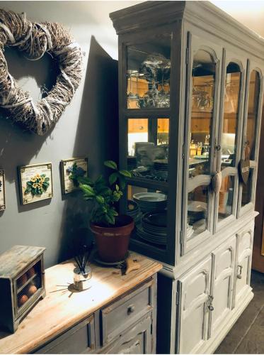 a china cabinet with dishes in it in a room at Woodend Cottage in Dumfries