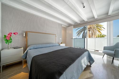 a bedroom with a large bed and a large window at Maspalomas Beach Point in San Bartolomé de Tirajana