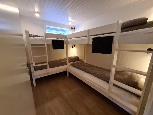 a room with two bunk beds and a window at Summarhús29 in Tvøroyri