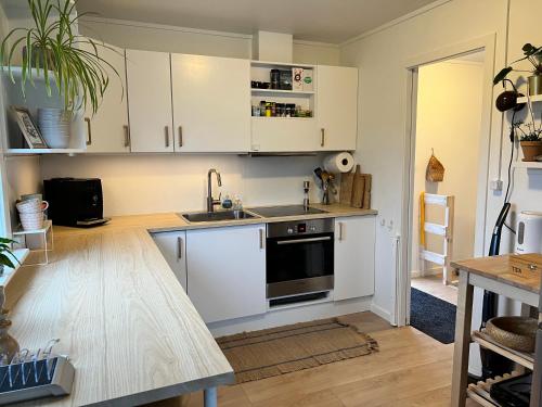 a kitchen with white cabinets and a sink at Summarhús29 in Tvøroyri