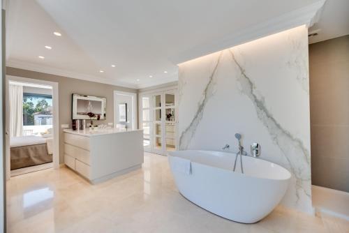 La salle de bains blanche est pourvue d'une baignoire et d'un lavabo. dans l'établissement VACATION MARBELLA I Villa Lina, Golf Valley, Jacuzzi, Close to the Marina, à Marbella