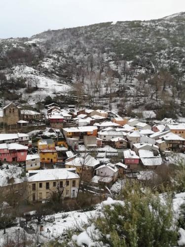 um grupo de casas cobertas de neve em Casa del patio em Villanueva de Valdueza