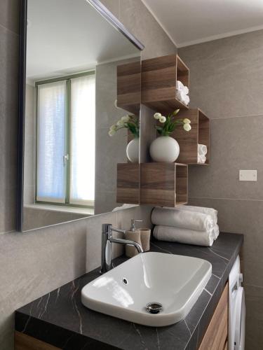 bagno con lavandino e specchio di Innesti Rooms&Apartments a Pergine Valsugana