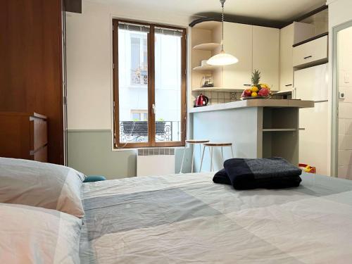 une chambre avec un grand lit et une cuisine dans l'établissement Eden Moon, à Paris