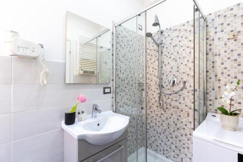 y baño blanco con lavabo y ducha. en Rome as you feel - Diocleziano Apartment, en Roma