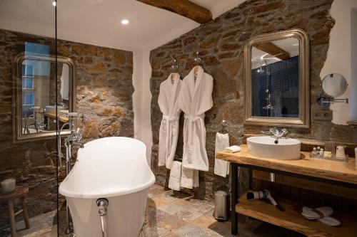 La salle de bains en pierre est pourvue d'un lavabo et d'une douche. dans l'établissement Le Clos de Mansart, à Grimaud