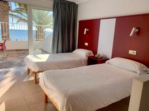 a hotel room with two beds and a balcony at Hospedium Hotel Continental in Mojácar