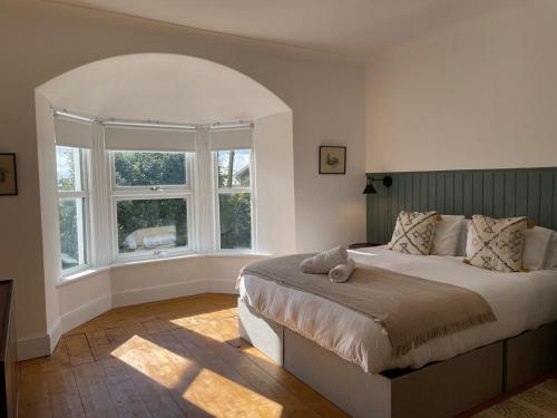 ein Schlafzimmer mit einem Bett und einem großen Fenster in der Unterkunft Bodorgan Inn By Birch Stays in Bodorgan