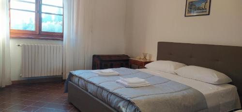 1 dormitorio con 1 cama con 2 toallas en Casolare L'Antico Olivo, en Chiesina Uzzanese