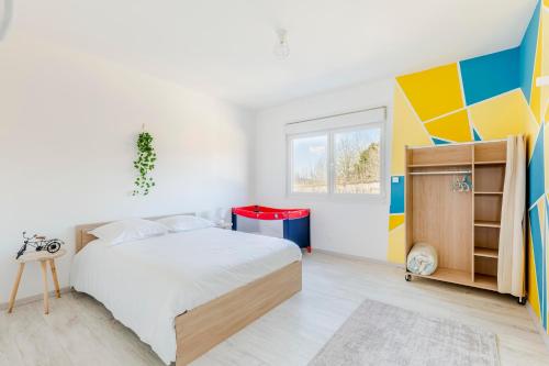 Bouvaincourt-sur-Bresle的住宿－Le Gîte des 5 étangs，一间卧室设有一张床和色彩缤纷的墙壁