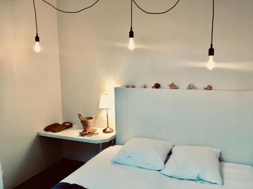 - une chambre avec un lit et une table éclairée dans l'établissement L'Atelier du Vieux Port avec Parking, à La Rochelle