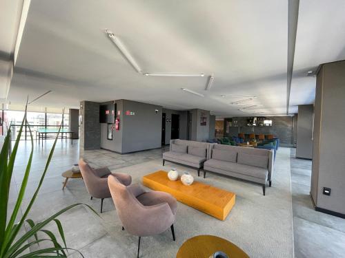 a living room with couches and a table and chairs at Studio Time 1312 - Luxo - Ponta Verde - Maceió-AL in Maceió